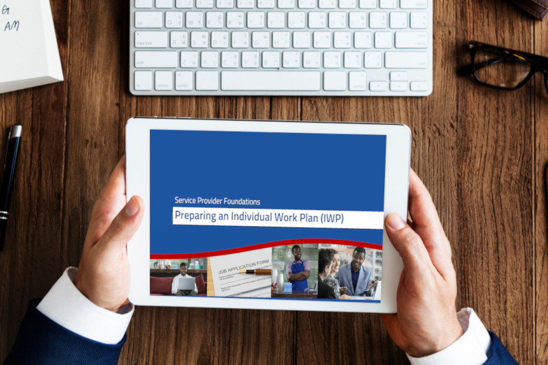 individual holding tablet with Preparing an Individual Work Plan (IWP) Service Provider Foundations module displaying on screen