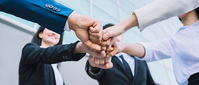 Image of people joining hands together.